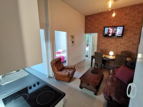 a living room with a couch and a tv on a brick wall at Captivating 4-Bed Apartment in Kotka SaunaFacility in Kotka