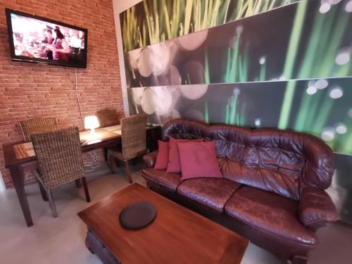 a living room with a brown leather couch and a table at Captivating 4-Bed Apartment in Kotka SaunaFacility in Kotka