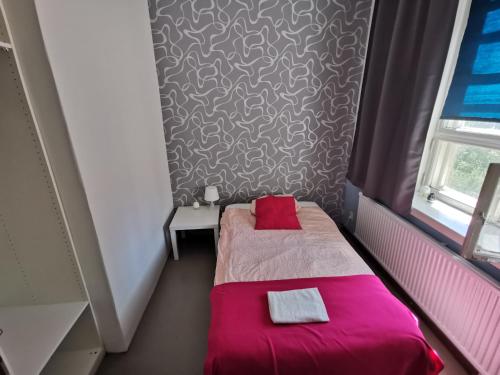 a small room with a bed with a red blanket at Captivating 4-Bed Apartment in Kotka SaunaFacility in Kotka