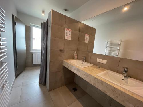a bathroom with two sinks and a large mirror at ANNA NOCLEGI in Raszyn