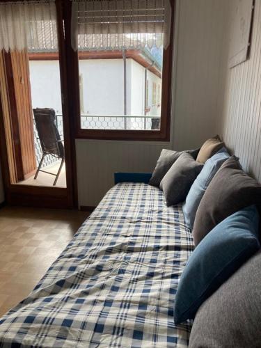 a bed in a room with a plaid blanket at Le Gildien in Bardonecchia
