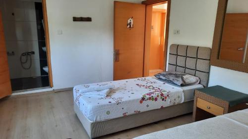 a small bedroom with two beds and a shower at Teo Hotel&Pansion in Cıralı