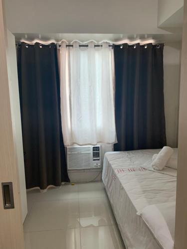 een kleine kamer met een bed en een raam bij 1 BR CONDO SEA RESIDENCES in Manilla