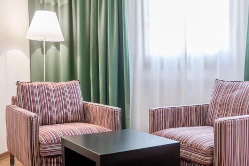 two chairs and a coffee table in a hotel room at Boutique Hotel Cervus in St. Moritz