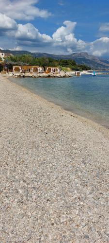 a rocky beach with houses and the water at Ana & Marija in Kaštela