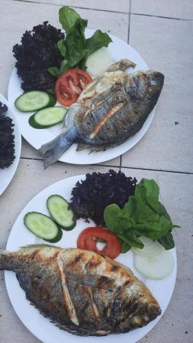 two plates of food with fish and vegetables on a table at Teo Hotel&Pansion in Cıralı