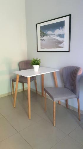 a table and two chairs with a potted plant on it at Willa Abrazja - wypoczynek dla dorosłych in Jastrzębia Góra