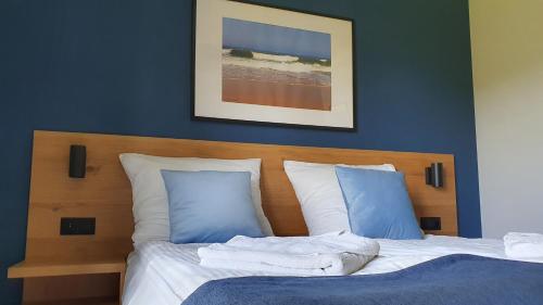 a bedroom with a bed with blue walls at Willa Abrazja - wypoczynek dla dorosłych in Jastrzębia Góra
