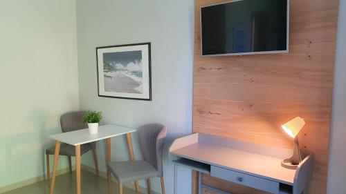 a room with a desk and a table and a tv at Willa Abrazja - wypoczynek dla dorosłych in Jastrzębia Góra
