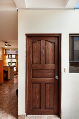a wooden door in a room with a kitchen at Hostel Tropical and CoWorking in San Juan del Sur