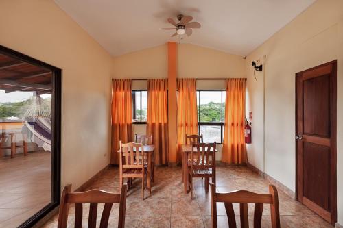 a dining room with a table and chairs and a mirror at Hostel Tropical and CoWorking in San Juan del Sur
