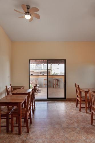 a dining room with wooden tables and chairs at Hostel Tropical and CoWorking in San Juan del Sur