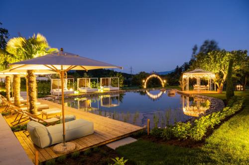 a pool with an umbrella and chairs and a table at Das Moerisch in Seeboden