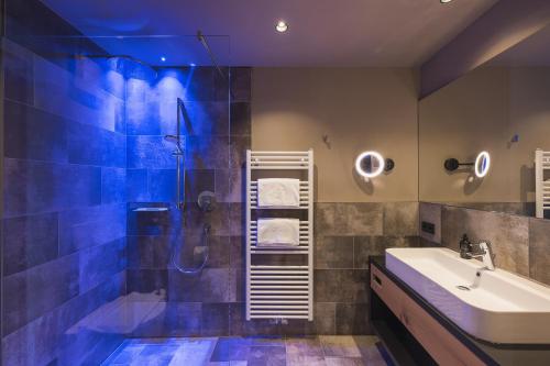 La salle de bains est pourvue d'une douche, d'un lavabo et d'une baignoire. dans l'établissement Landsitz Stroblhof, à Tirolo