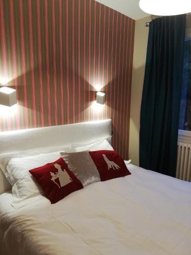 una camera con un letto con due cuscini sopra di lilou a Biganos