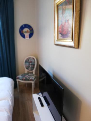 Una habitación con una cama, un televisor y una silla. en lilou, en Biganos