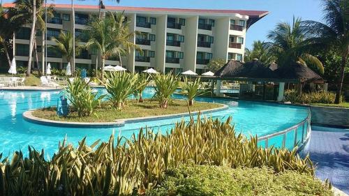 a resort with a pool with palm trees and a building at Studio Experience Marulhos Resort in Porto De Galinhas