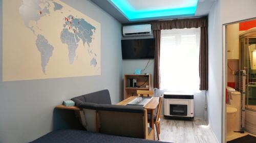 Habitación con escritorio y mapa mundial en la pared. en Belvarosi Exkluzív Minigarzon en Debrecen