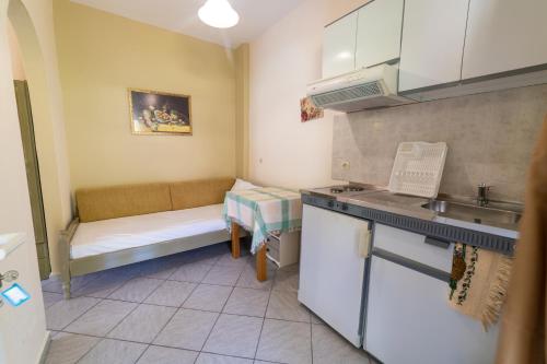 a small kitchen with a couch and a table at Lambrini Studios in Parga