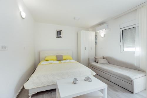 biała sypialnia z łóżkiem i kanapą w obiekcie Todorovic apartmani w mieście Herceg Novi