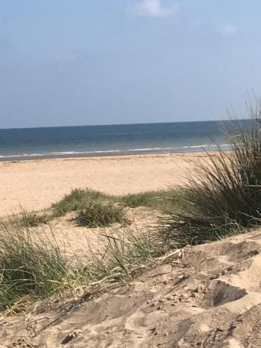 Le Foch في اويسترهام: شاطئ رملي مع بعض العشب والمحيط