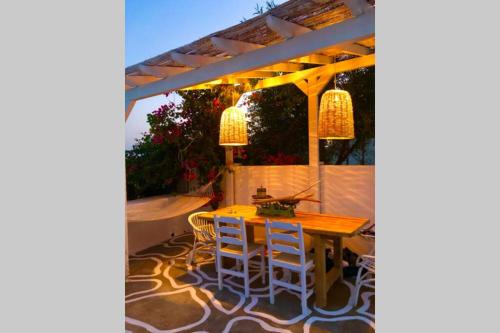 a patio with a table and chairs under a pergola at The Summer Pink House in Lachania