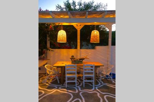 a patio with a table and chairs under a pergola at The Summer Pink House in Lachania