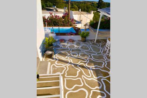 a patio with a stone floor with a pool at The Summer Pink House in Lachania