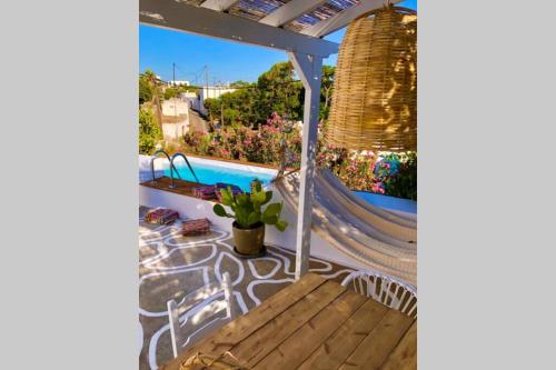 a patio with a hammock and a swimming pool at The Summer Pink House in Lachania