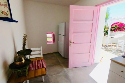 a pink door in a kitchen with a refrigerator at The Summer Pink House in Lachania