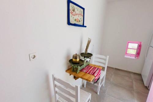 a dining room with a table and two chairs at The Summer Pink House in Lachania