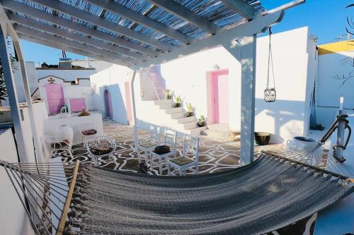 a porch with a hammock on a house at The Summer Pink House in Lachania