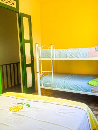 a room with two bunk beds and a yellow wall at Hostel da Providência in Salvador