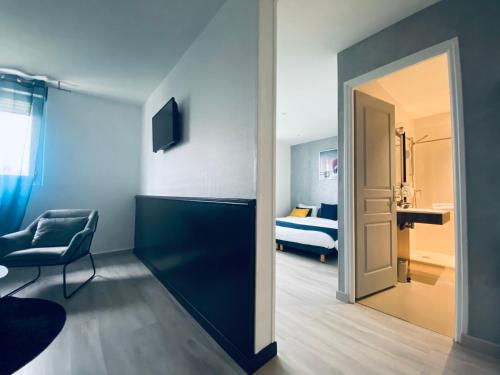 a room with a bed and a chair and a door at Hotel Air-lane in Saint-Léger-sous-Brienne