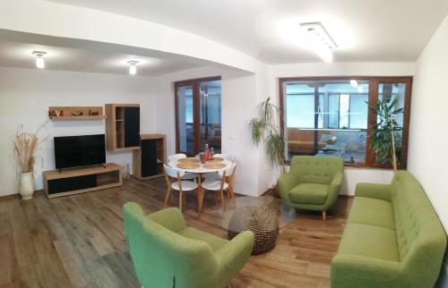 salon z zielonymi krzesłami i stołem w obiekcie Ema guest house w Warnie