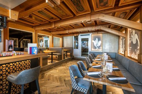 a restaurant with wooden ceilings and wooden tables and chairs at Hotel Alpina in Obertauern