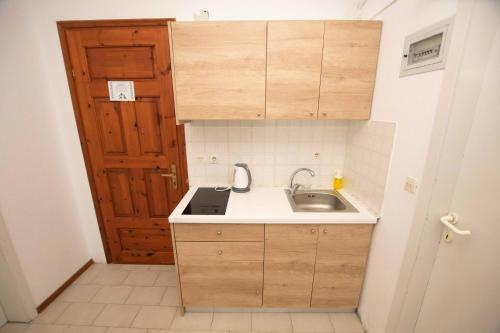 a small kitchen with a sink and a wooden door at Katerina's Garden Mola Kaliva in Mola Kalyva