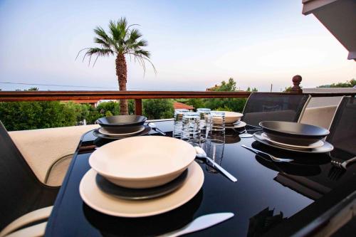 a table with bowls and plates on top of a balcony at Katerina's Garden Mola Kaliva in Mola Kalyva