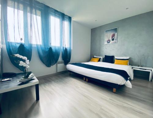 a bedroom with a large bed with blue curtains at Hotel Air-lane in Saint-Léger-sous-Brienne