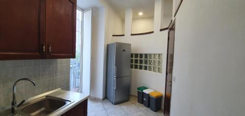 een keuken met een roestvrijstalen koelkast naast een raam bij la casa di Maya in Napels