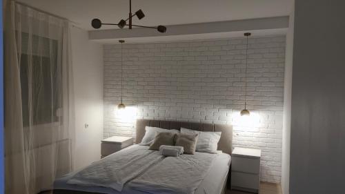 Vila Maksim Sokobanja في سوكو بانيا: غرفة نوم بجدار من الطوب الأبيض وسرير