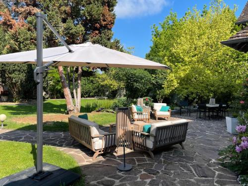 - une terrasse avec 2 chaises et un parasol dans l'établissement La Collinière, à Sainte-Gemme-Moronval