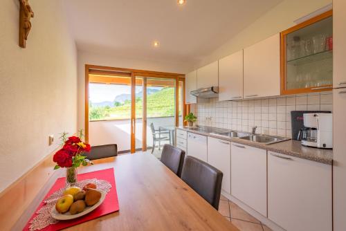 a kitchen with a table with a bowl of fruit on it at Finkenhof: Ferienwohungen - Urlaub auf dem Bauernhof in Termeno