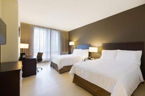 Holiday Inn Panama Distrito Financiero, an IHG Hotel tesisinde bir odada yatak veya yataklar
