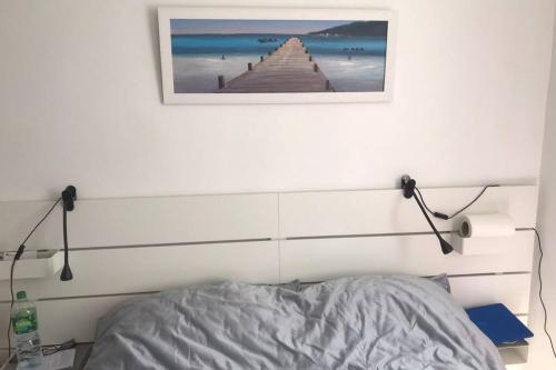 a bedroom with a bed and a picture on the wall at La petite oasis, newly renovated in Toulon