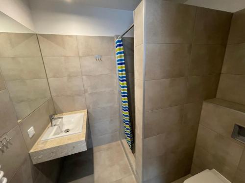 a small bathroom with a sink and a shower at ANNA NOCLEGI in Raszyn