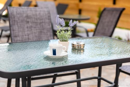 a table with a cup of coffee and flowers on it at Villa Pino in Velingrad
