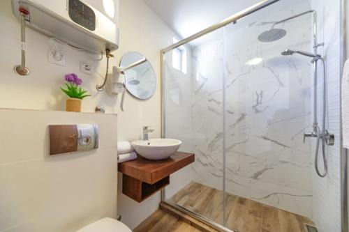 un baño con ducha y lavabo en Mika's Seaview Apartments, en Bar