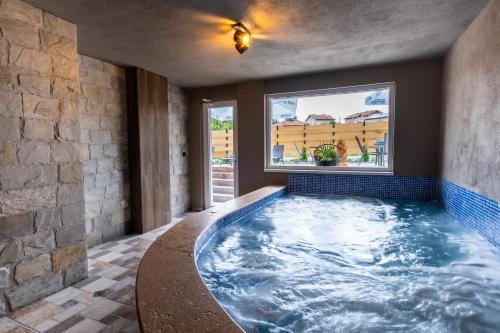 uma banheira de hidromassagem num quarto com uma janela em Villa Pino em Velingrad
