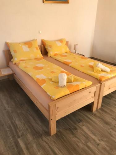two twin beds in a room with yellow sheets at Apartments & Rooms Preseren in Bled